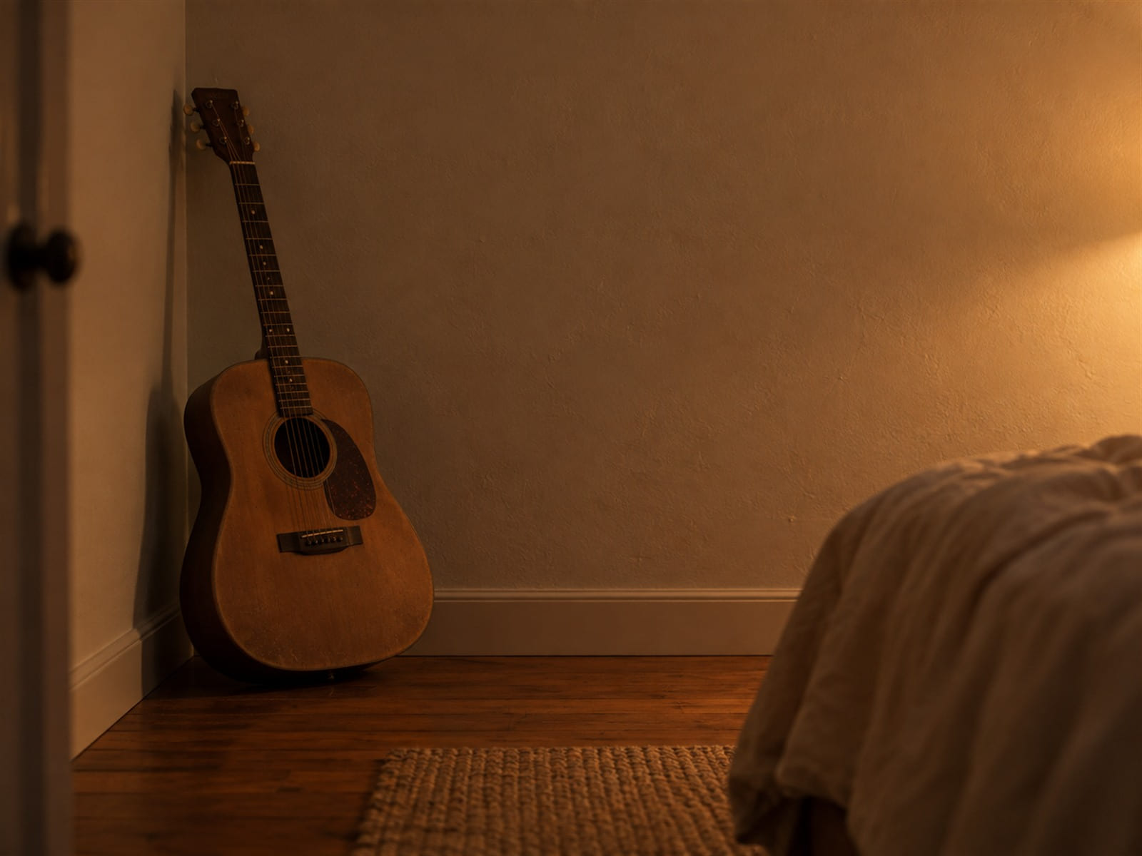 A dusty guitar leaning in the corner of a quiet bedroom