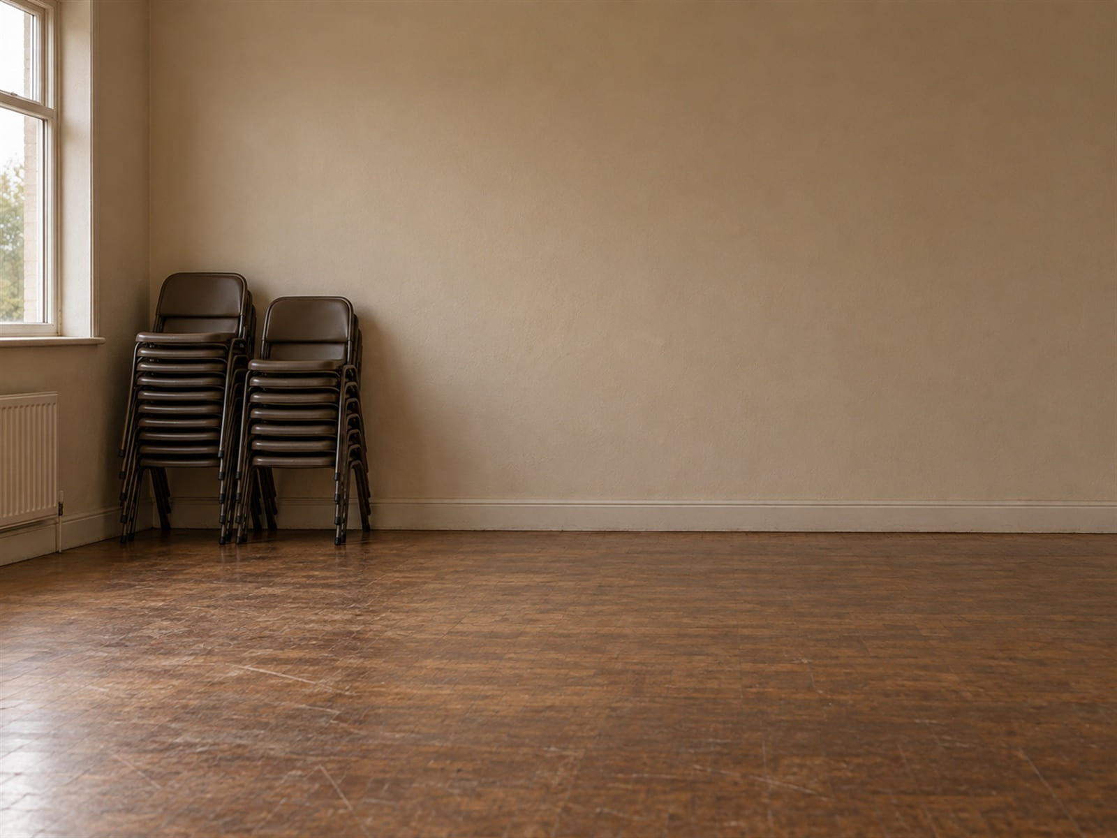 An empty church hall with folding chairs stacked against the wall