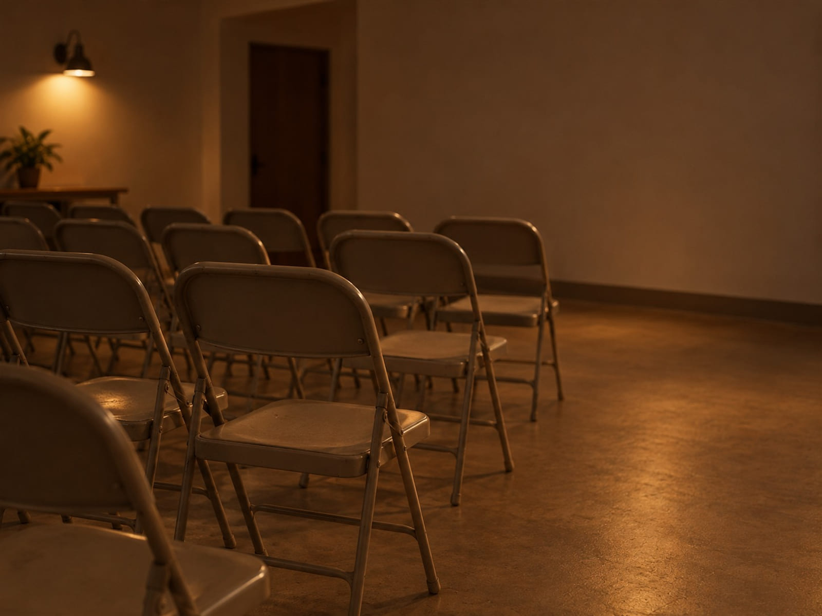 Rows of folding chairs set out in a plain community room in morning light