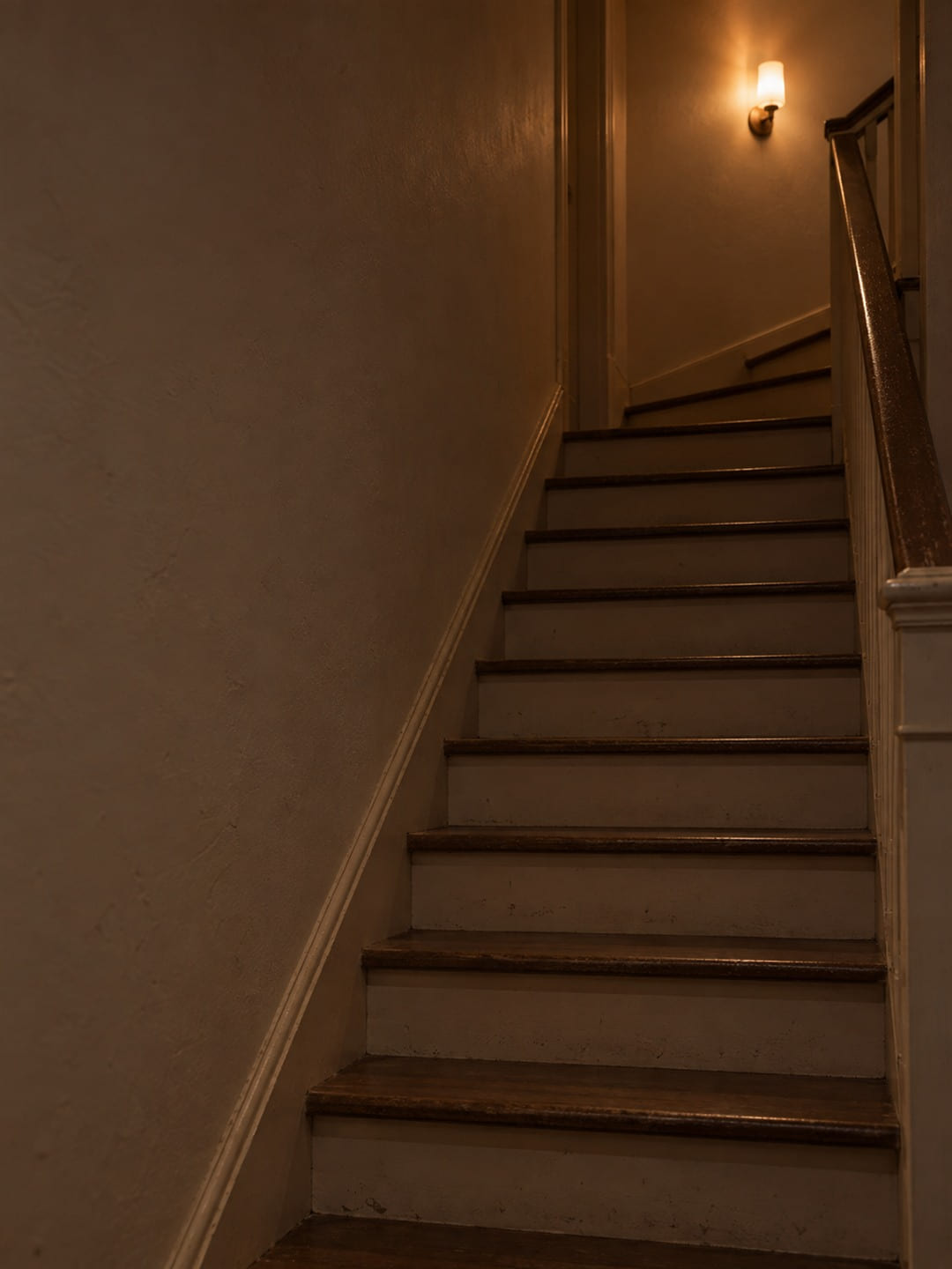 A stairwell at the end of the day with one light two floors up